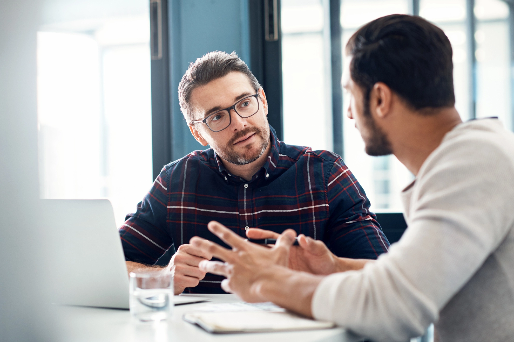 Zwei Männer im Gespräch sitzen an einem Tisch